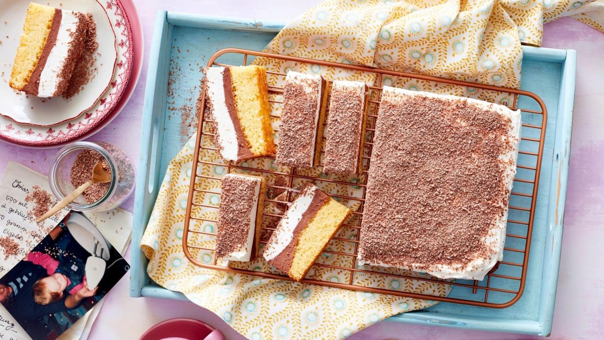 Süße Schoko-Schnitten mit Pudding und Schmand auf einem blauen Tablett, das auf einem gedeckten Tisch steht