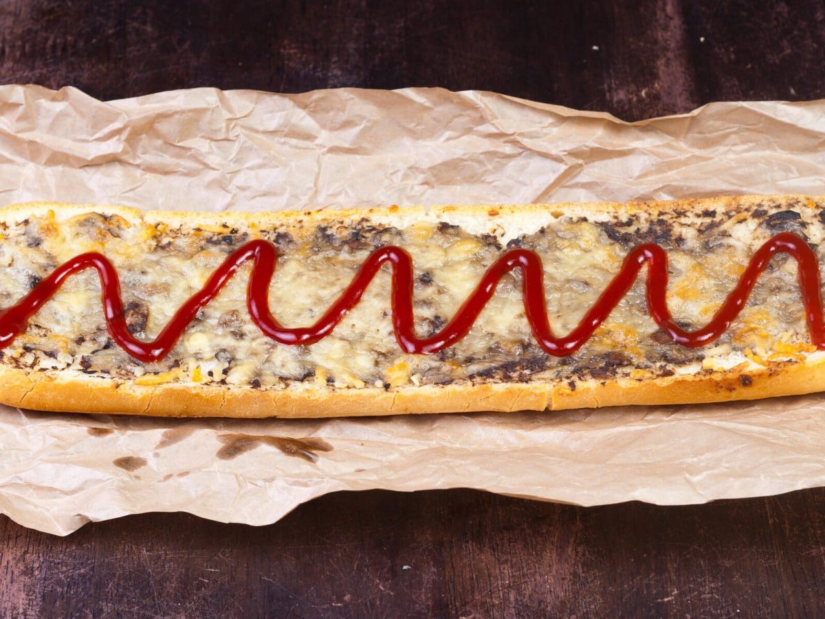 Belegtes Baguette Zapiekanka mit Pilzen, Käse und Ketchup.