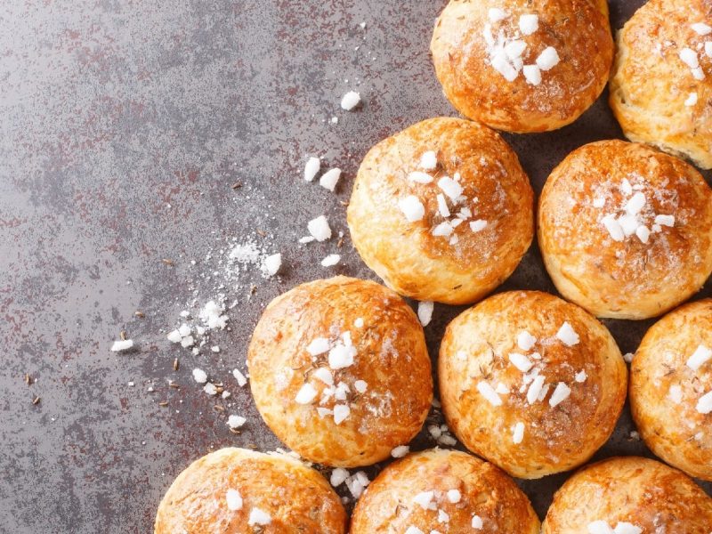 Englische Bath Buns mit Zuckerglasur auf grauem Beton-Hintergrund