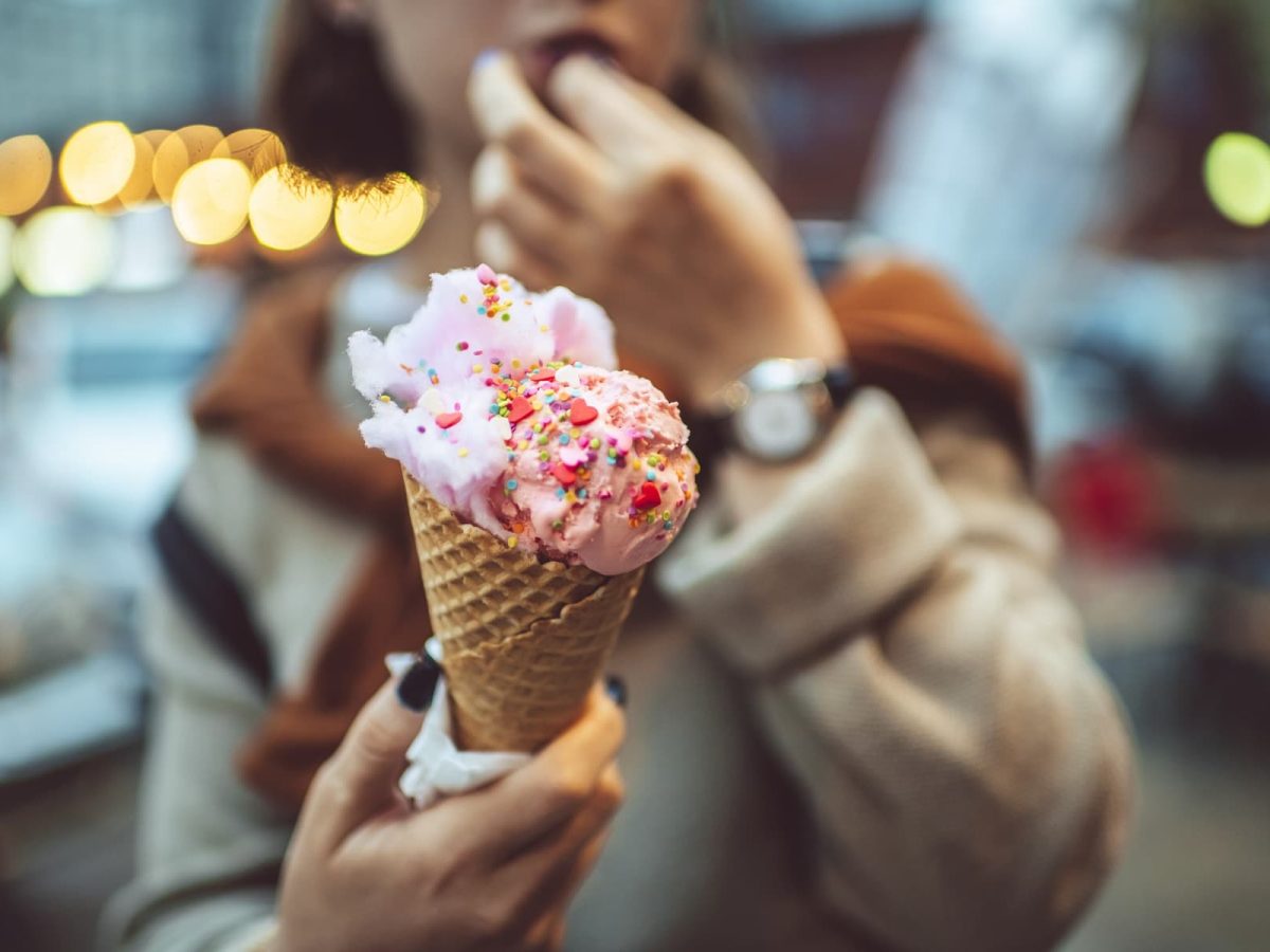 Berlin ICe Cream Week: Ein junges Mädchen hält eine Eiswaffel mit einer roten Kugel und Streuseln in die Kamera.