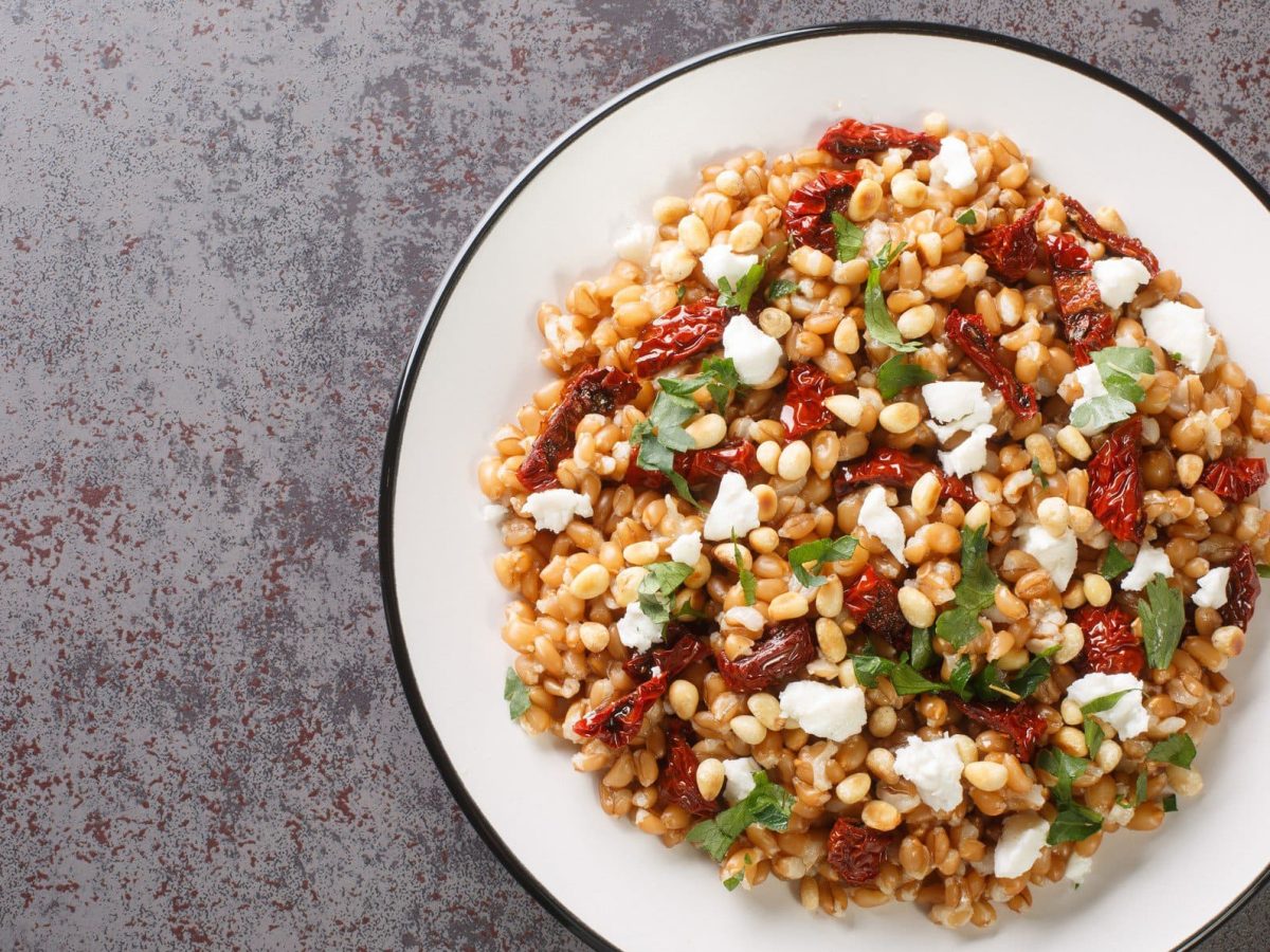 Farro Salat in einer weißen Schale auf grauem Untergrund.