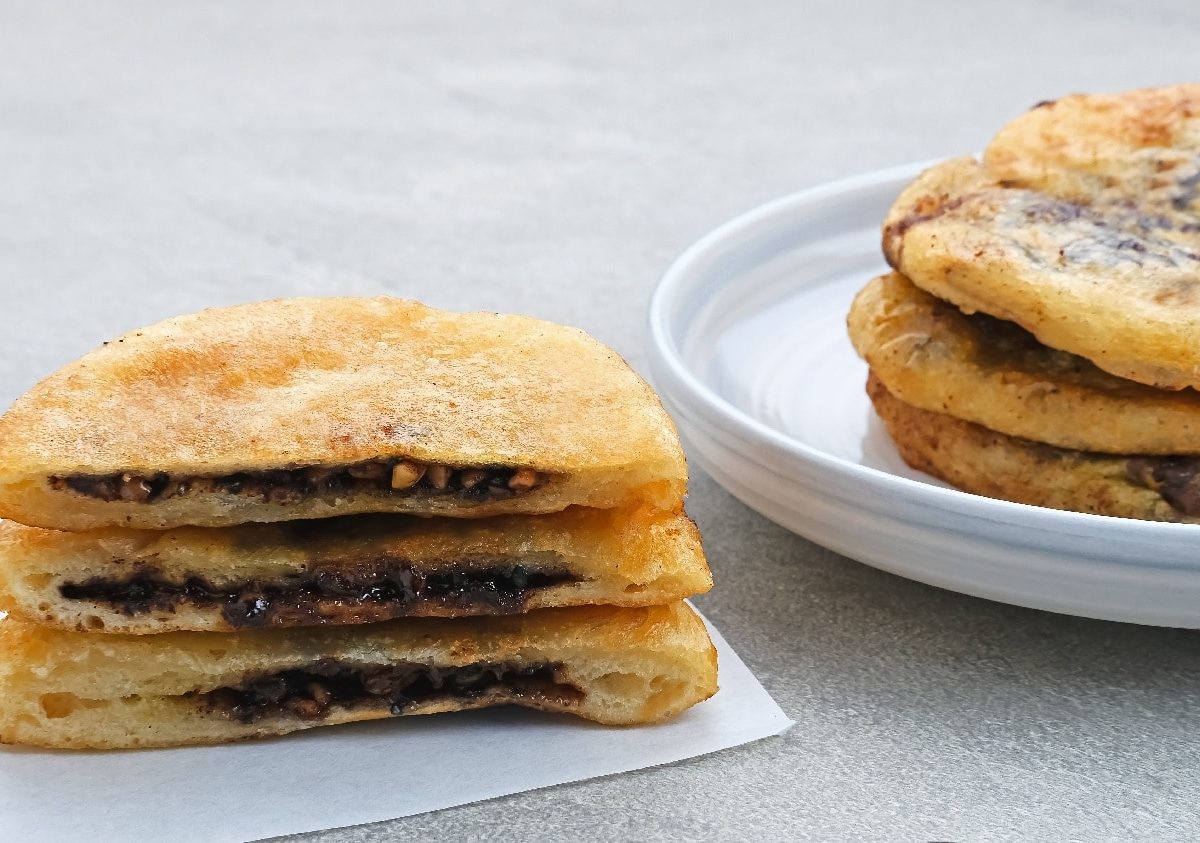 Mehrere koreanische Pfannkuchen auf einem grauen Untergrund und einem weißen Teller.