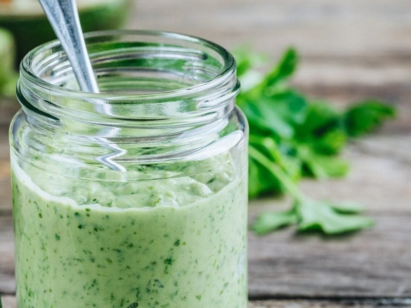 In einem Glas ist eine selbstgemachte Koriander-Mayonnaise mit Limetten.