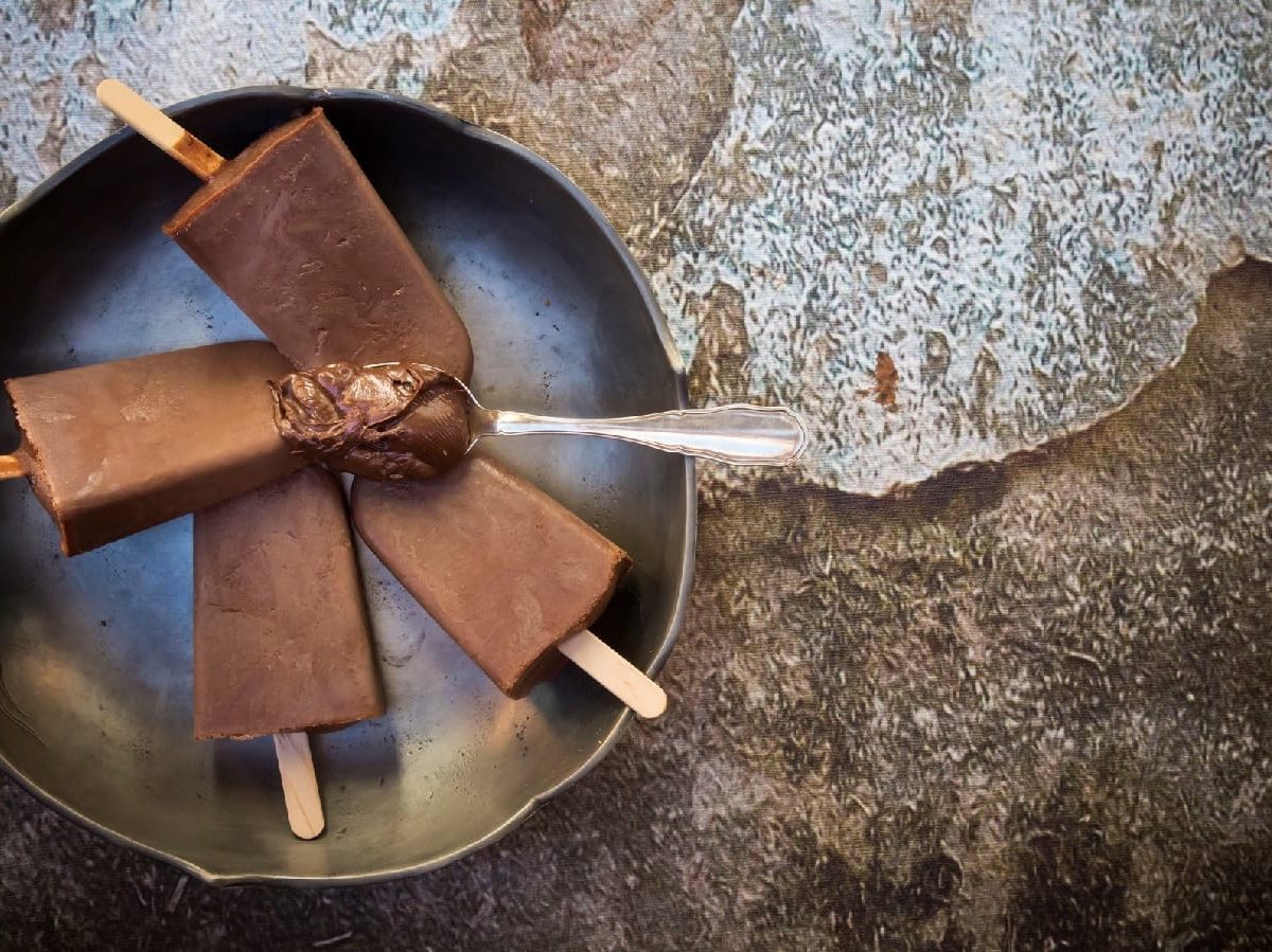 Nutella Popsicles mit einem Löffel Nutella auf einem Steinhintergrund