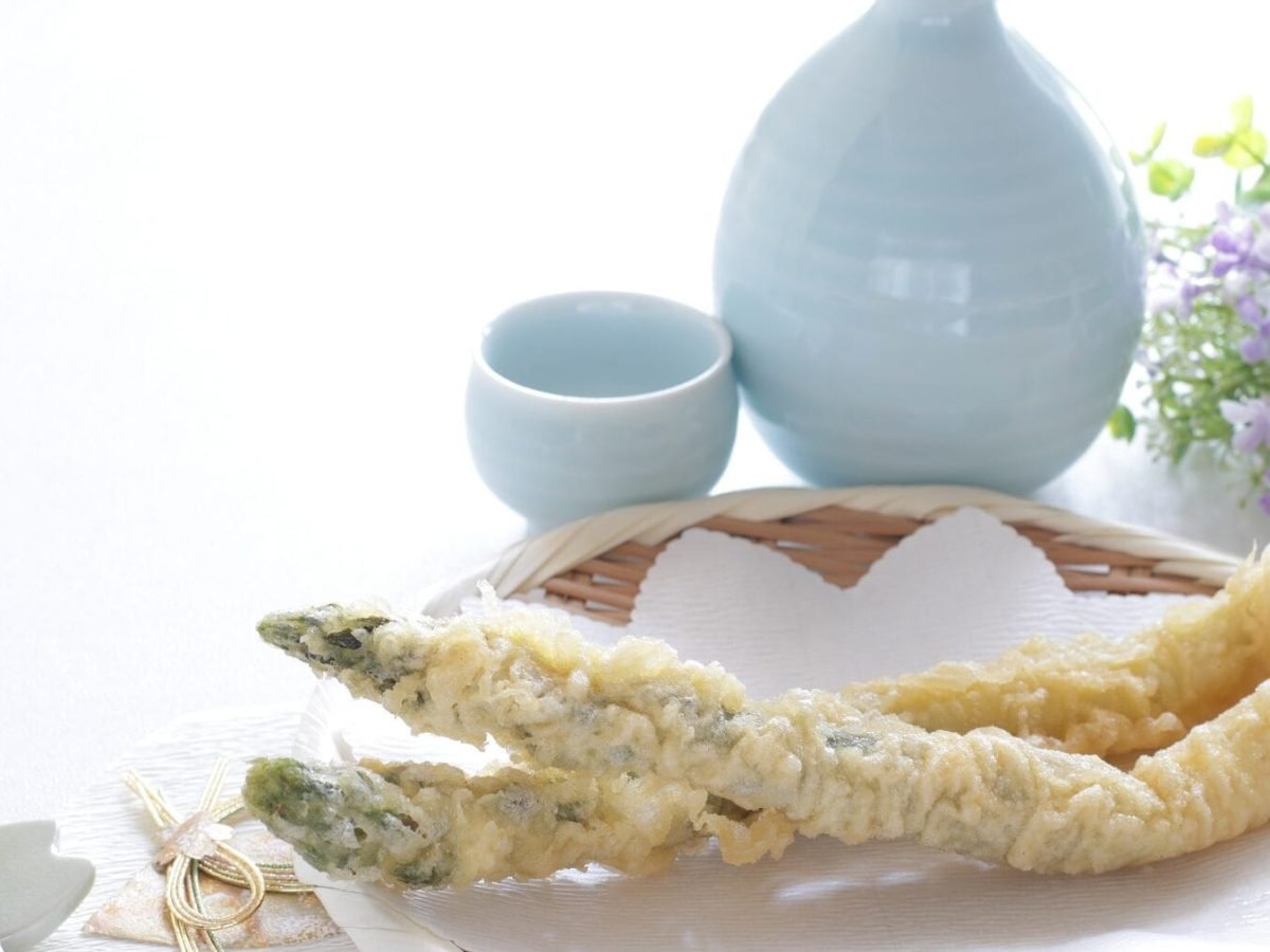 Auf einem Teller liegt Spargel-Tempura. Das sind frittierte Spargelstangen