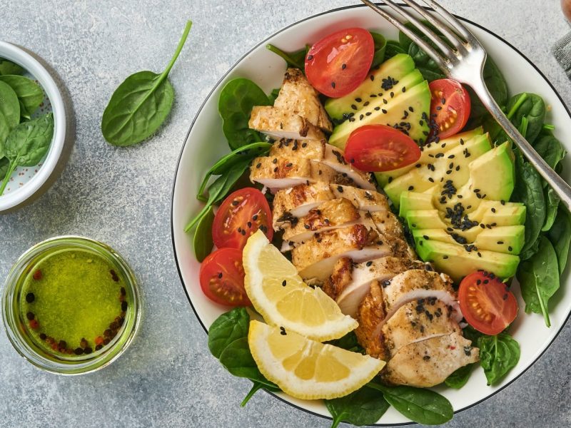 Ein Teller mit Hähnchensalat mit Honig-Zitronen-Dressing und Avocado.