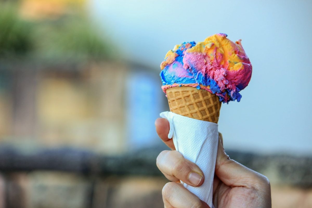 Ice Cream & Sweets Festival N°1 Hamburg: Eine Frau hält eine Eiswaffel mit einer Kugel Eis in Regenbogenfarben.