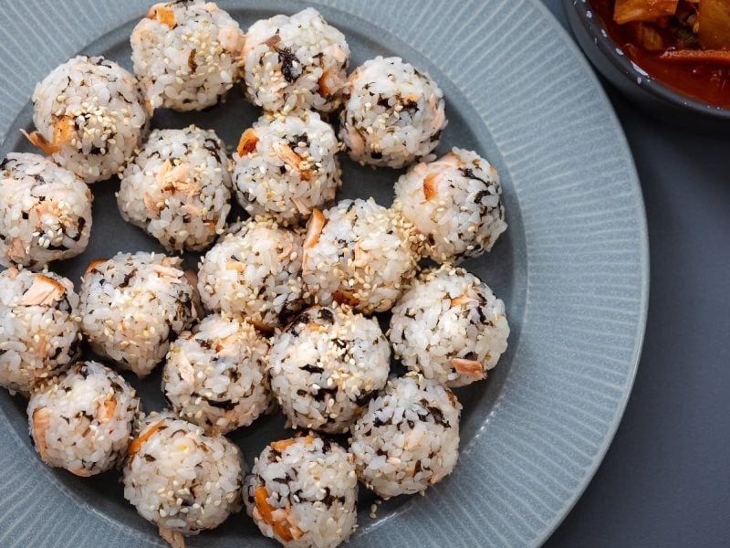 Jumeokbap, koreanische Reisbällchen, auf einem hellen runden Teller.