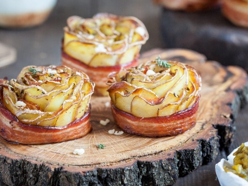 Drei Kartoffelrosen auf einer Baumscheibe und daneben eine kleine Schale mit Gurkenrelish.