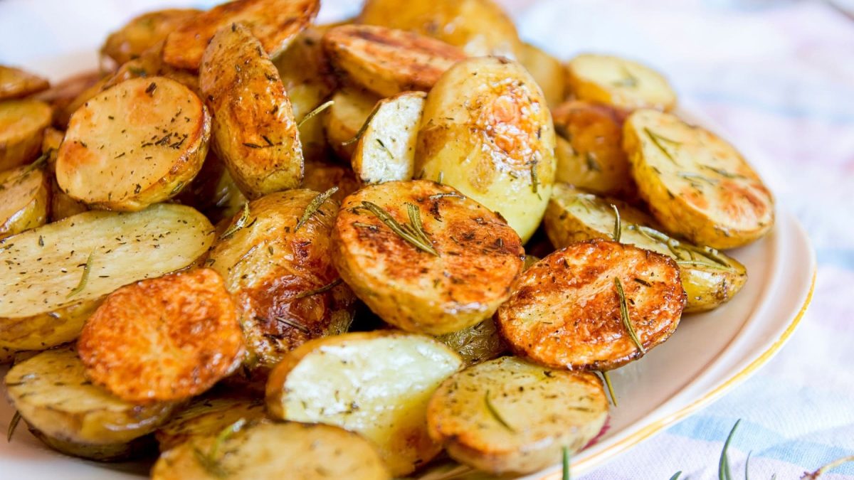 halbierte Knoblauchkartoffeln mit Zitrone und Rosmarin auf einem Teller