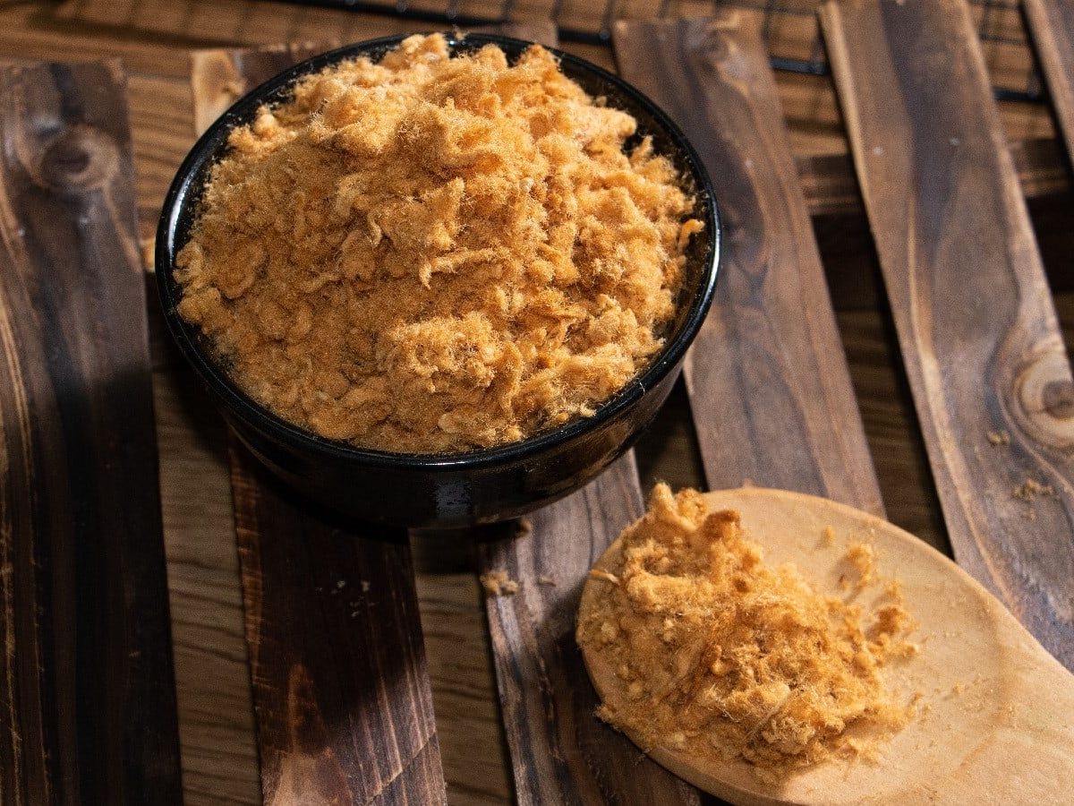 Eine Schale Pork Floss auf einem braunen Holztisch