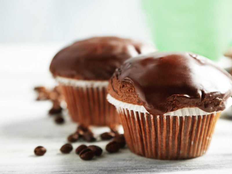 Zwei vegane Schokomuffins mit Karamellkern und Schokoladen-Ganache.