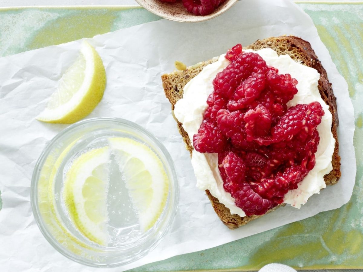 Himbeeren auf Brot auf einem gelben Tablett