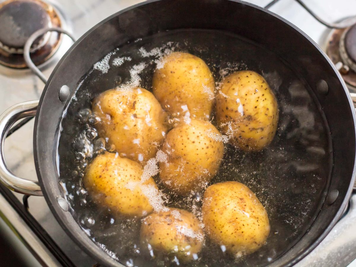 Kartoffeln kochen in einem altmodischem Topf auf Gasherd.