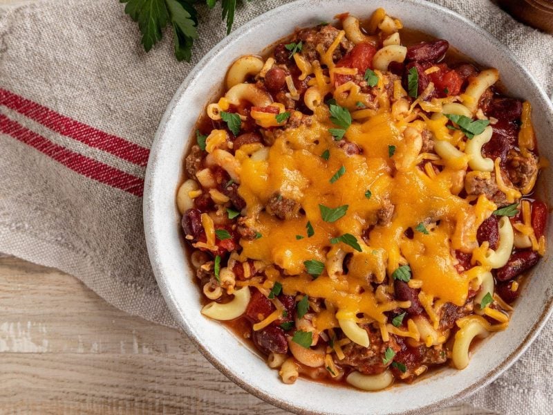 Chili-con-Carne-Pasta mit zerlaufenem Cheddar in weißer Schüssel.