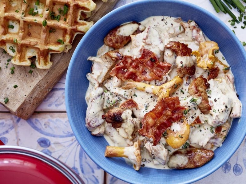 Filet-Gulasch in einer blauen Schale. Daneben Kartoffewaffeln auf einem Holzbrett.