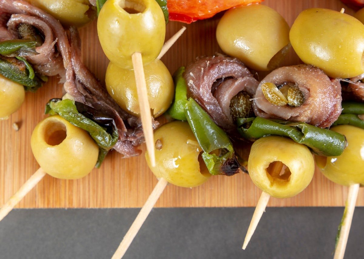 Gildas kleine kalte Tapas Spieße auf Holzbrett. Draufsicht.