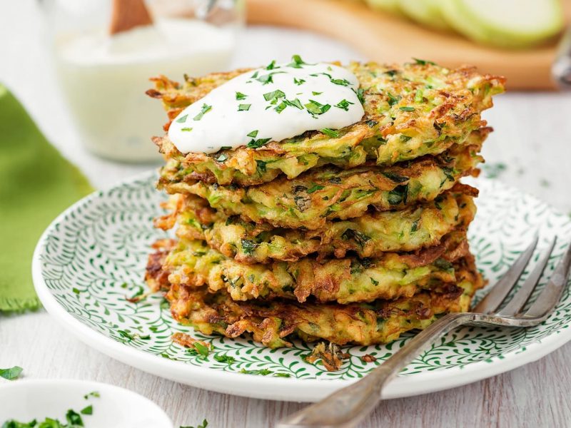 Ein Stapfel Kartoffelpuffer mit Mangold, darauf Quark.