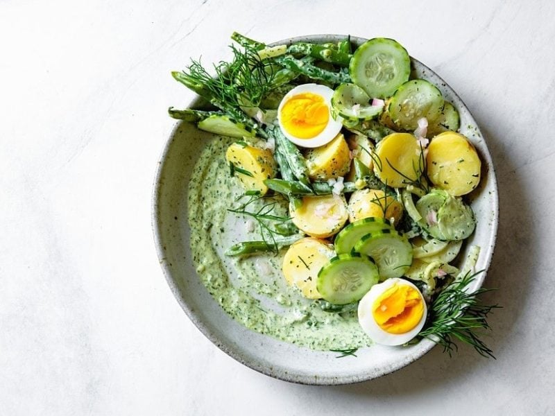 Grüner Kartoffelsalat in einer weißen Schale