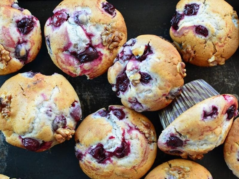 auf einem dunklen Untergrund stehen viele Kirsch-Muffins.