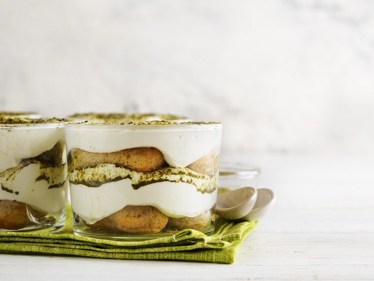 Zwei Gläser mit Matcha-Tiramisu auf einem grünen Tuch