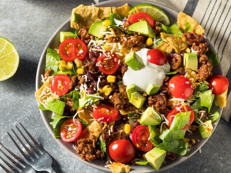 Eine Schüssel mit Taco-Salat auf zwei Küchentüchern.