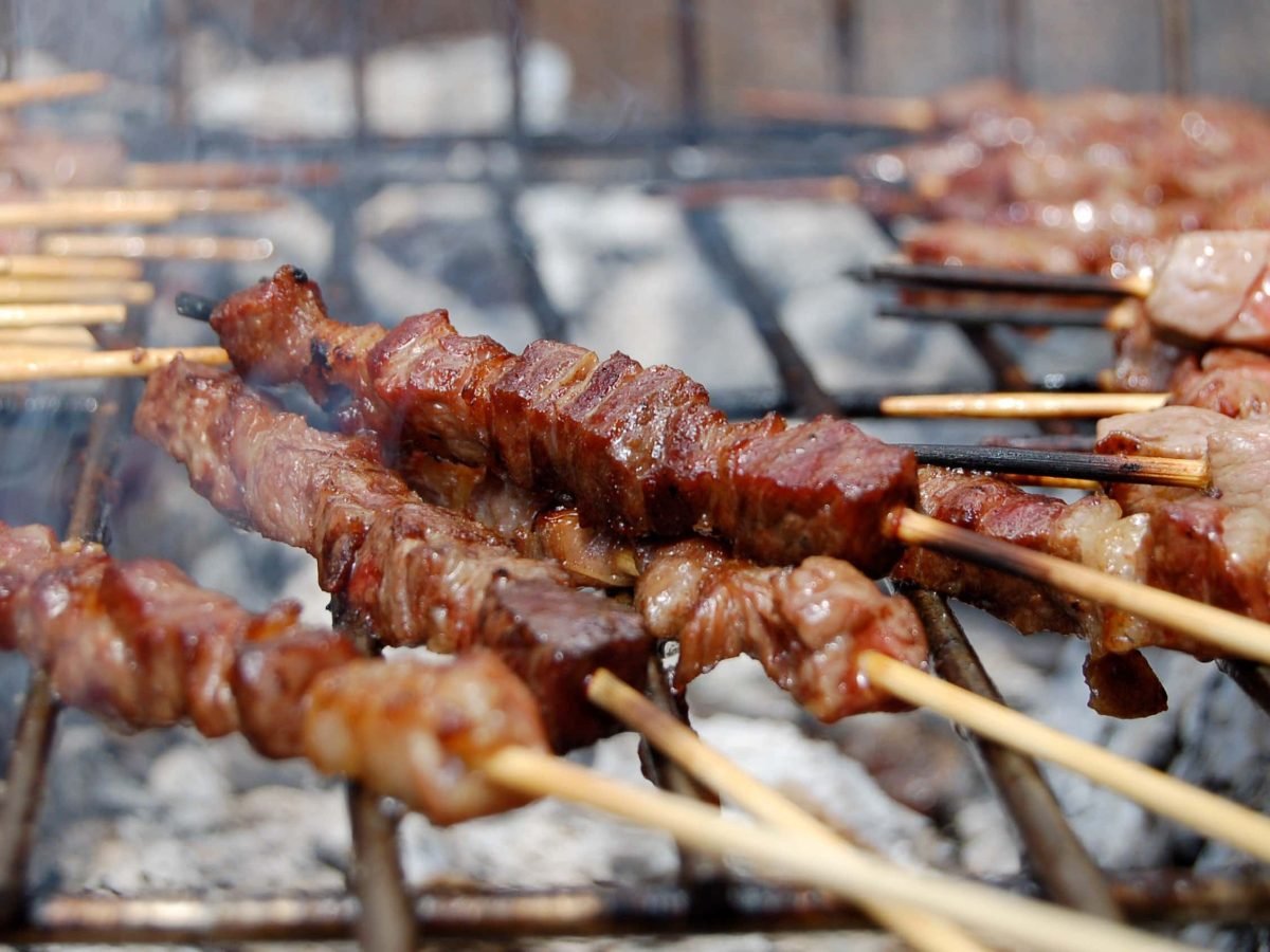 Italienische Arrosticini gegrillte Hammelspieße aus den Abruzzen auf Grillrost. Frontalansicht