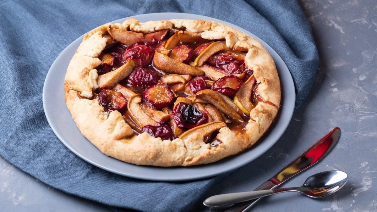 Die Galette auf einem grauen Teller, einer petrol-blauen Tischdecke und einem grau-weiß marmorierten Tisch.