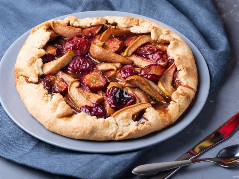 Die Galette auf einem grauen Teller, einer petrol-blauen Tischdecke und einem grau-weiß marmorierten Tisch.