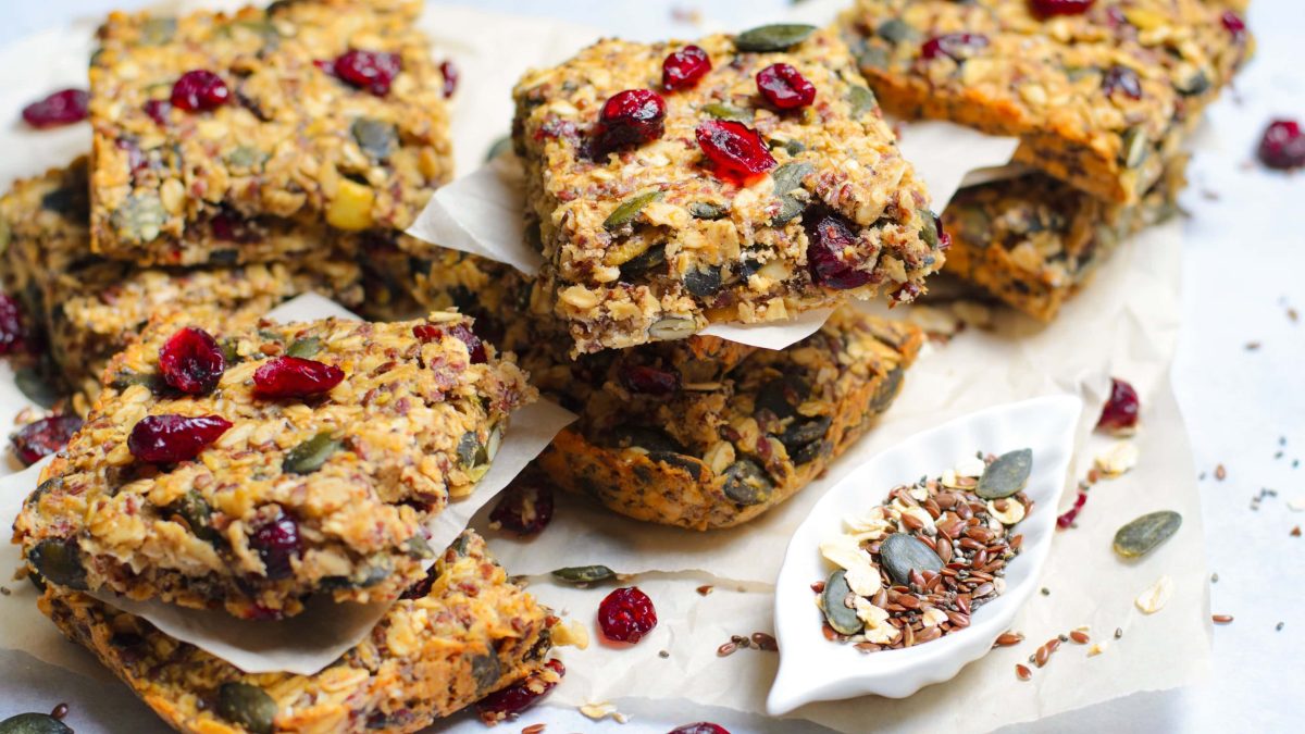 Mehrere Stücken Granola-Bars auf weißem Pergamentpapier und einem hellem Marmortisch