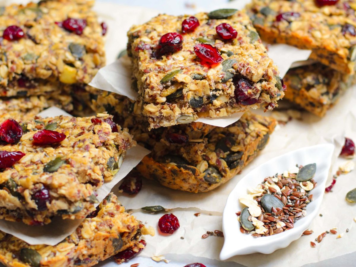 Mehrere Stücken Granola-Bars auf weißem Pergamentpapier und einem hellem Marmortisch