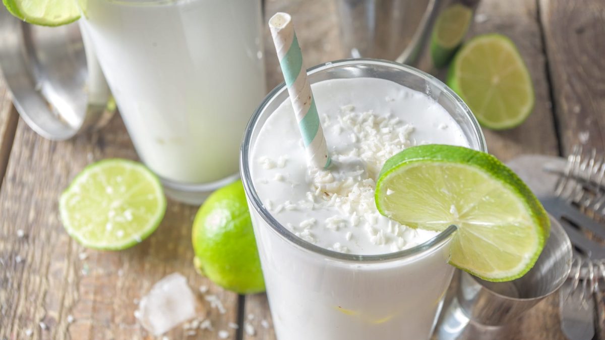 Ein Glas mit Kokosnuss-Mojito und frischer Limette.