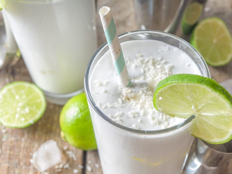 Ein Glas mit Kokosnuss-Mojito und frischer Limette.