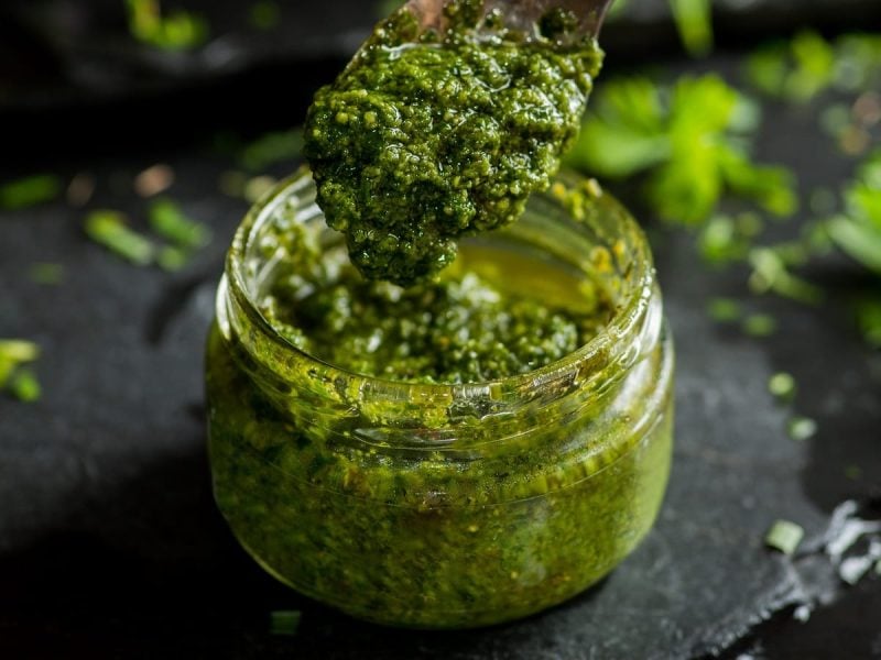 Ein Glas mit Thai-Basilikum-Pesto vor einem dunklen Hintergrund