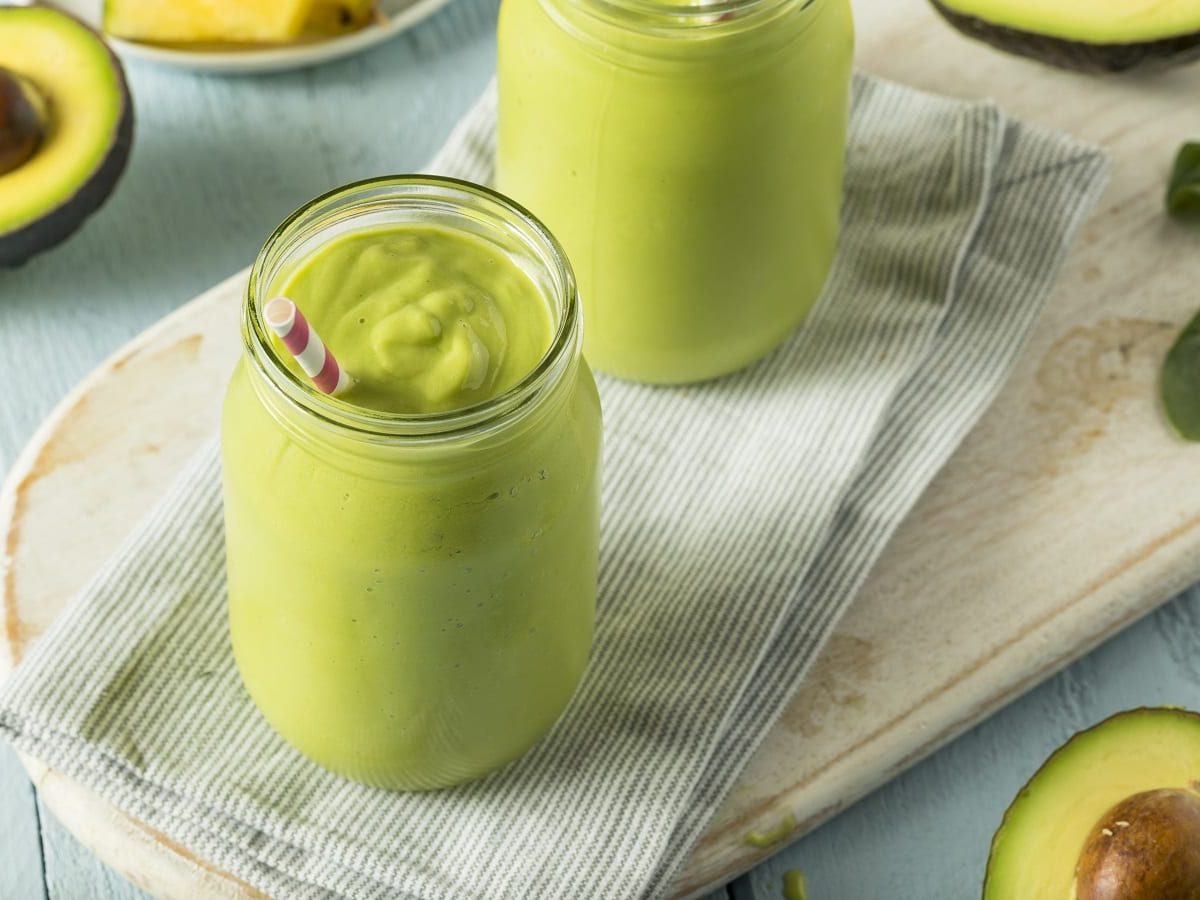 Ein Glas mit Sinh To Bo neben frischen Avocados