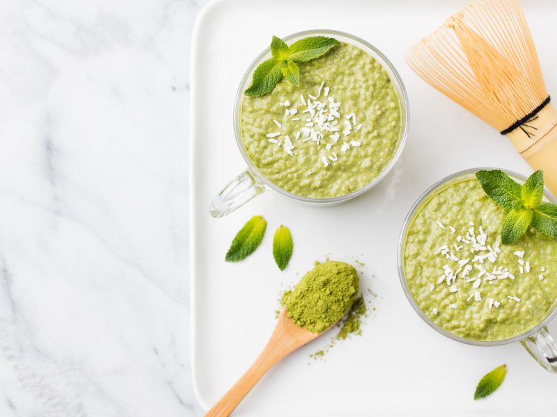 Ein quadratischer weißer Teller mit Matcha-Pudding mit Chia.