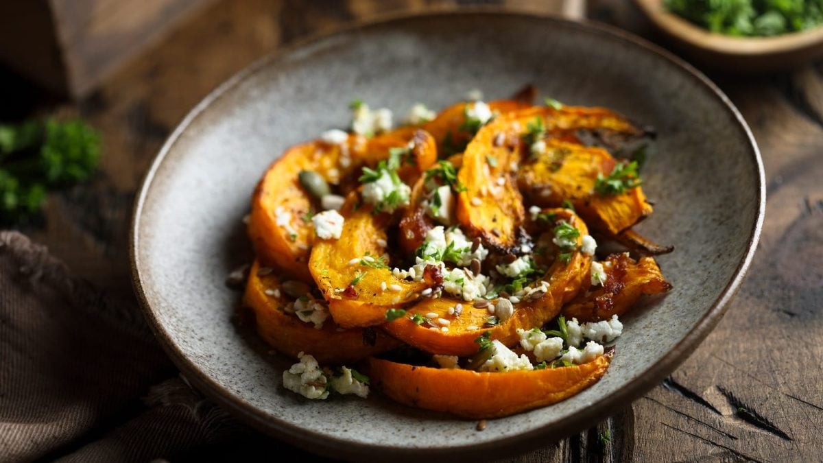 Ein Teller mit geröstetem Kürbis mit Feta und Kräutern