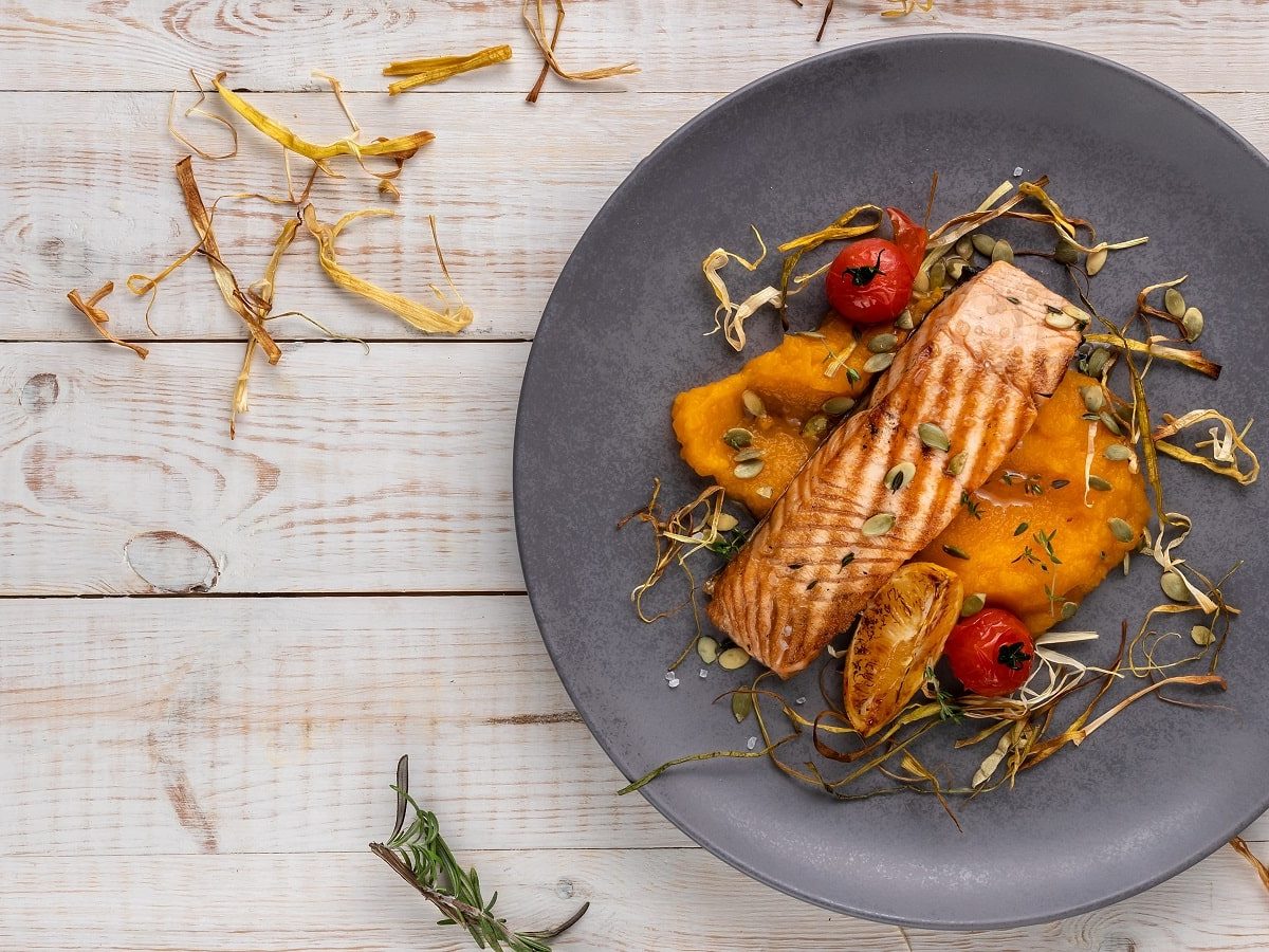 Ein grauer Teller mit Lachs-Steak auf Kürbispüree