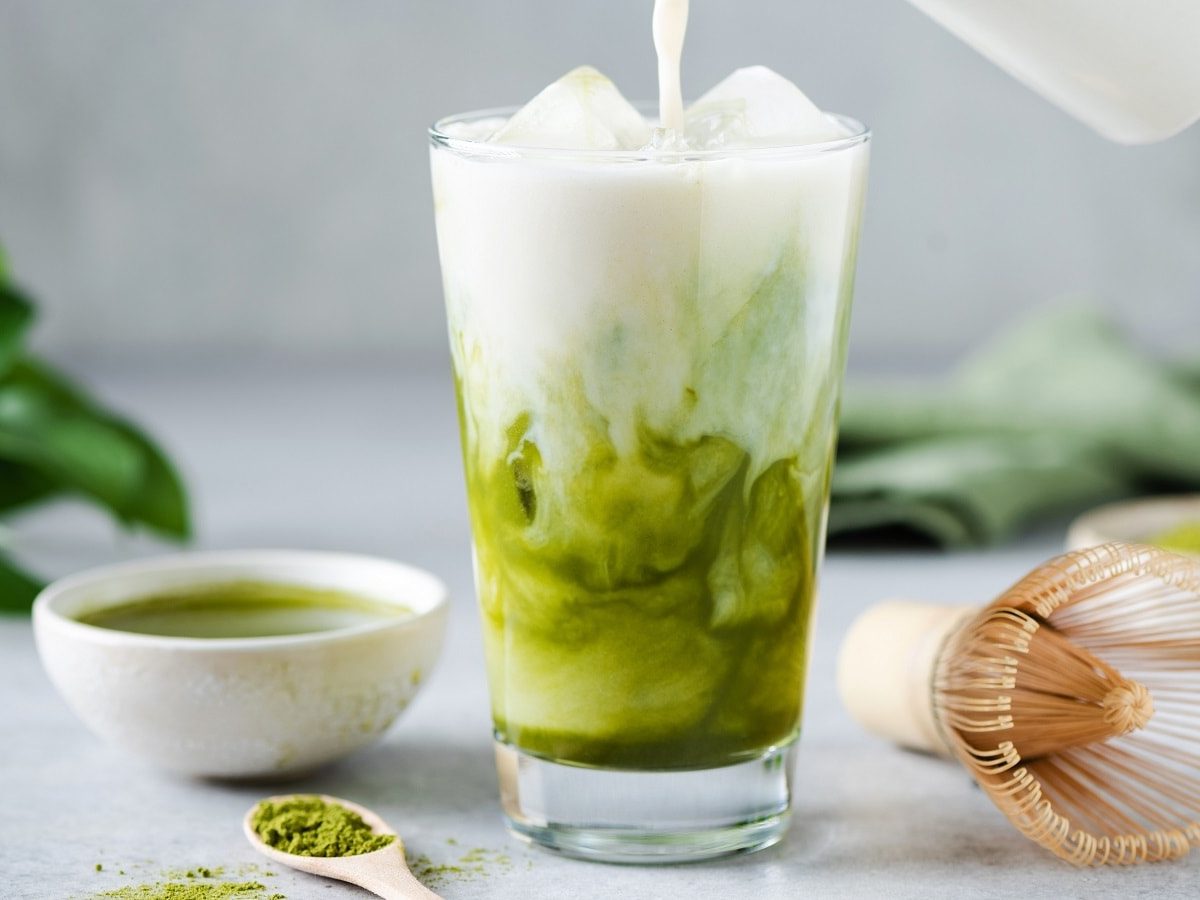 Ein Glas mit Matcha-Kokos-Latte gefüllt.