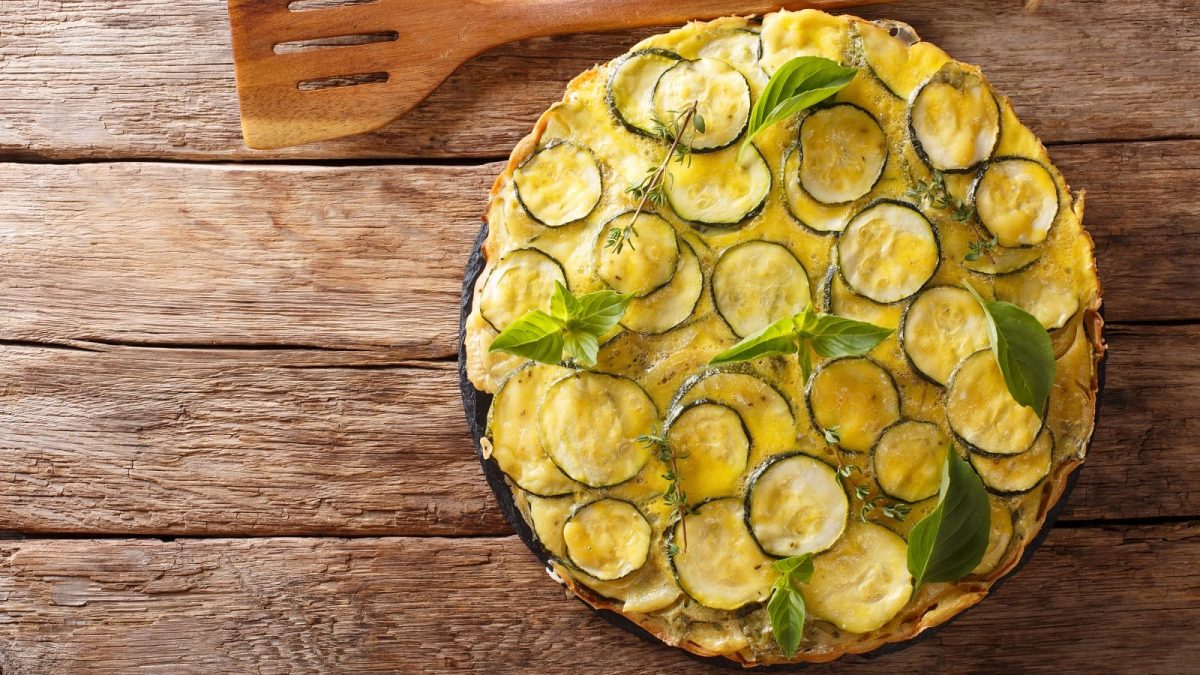 Ein Teller mit Scarpaccia salata auf einem Holztisch.