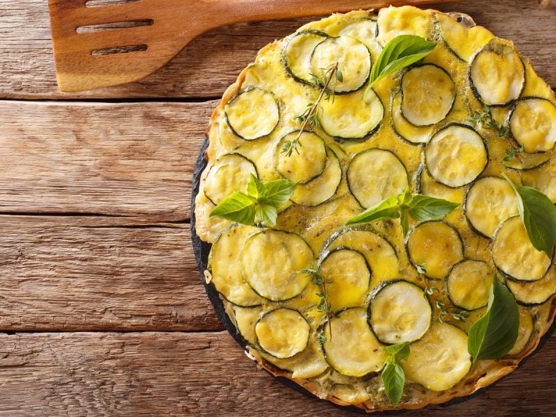 Ein Teller mit Scarpaccia salata auf einem Holztisch.