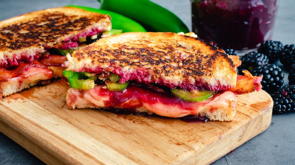 Grilled Cheese mit Jalapeño und Brombeeren auf einem Holzbrett.