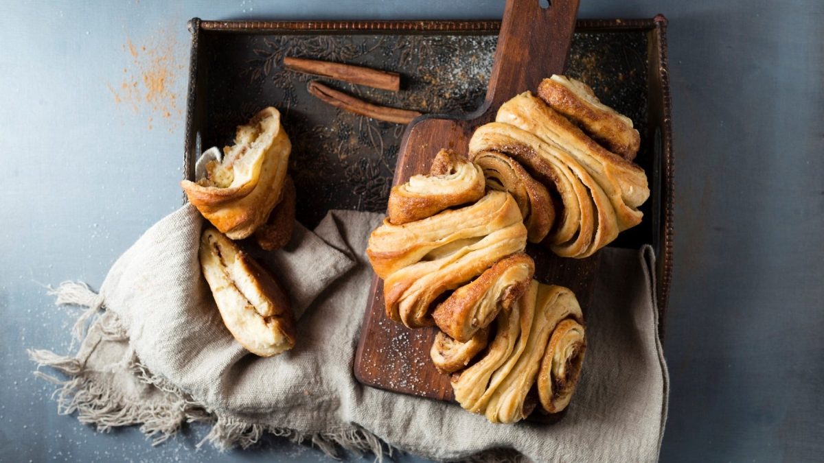 Ein paar vegane Franzbrötchen auf einem Tablett mit einer Stoffserviette in der Draufsicht.