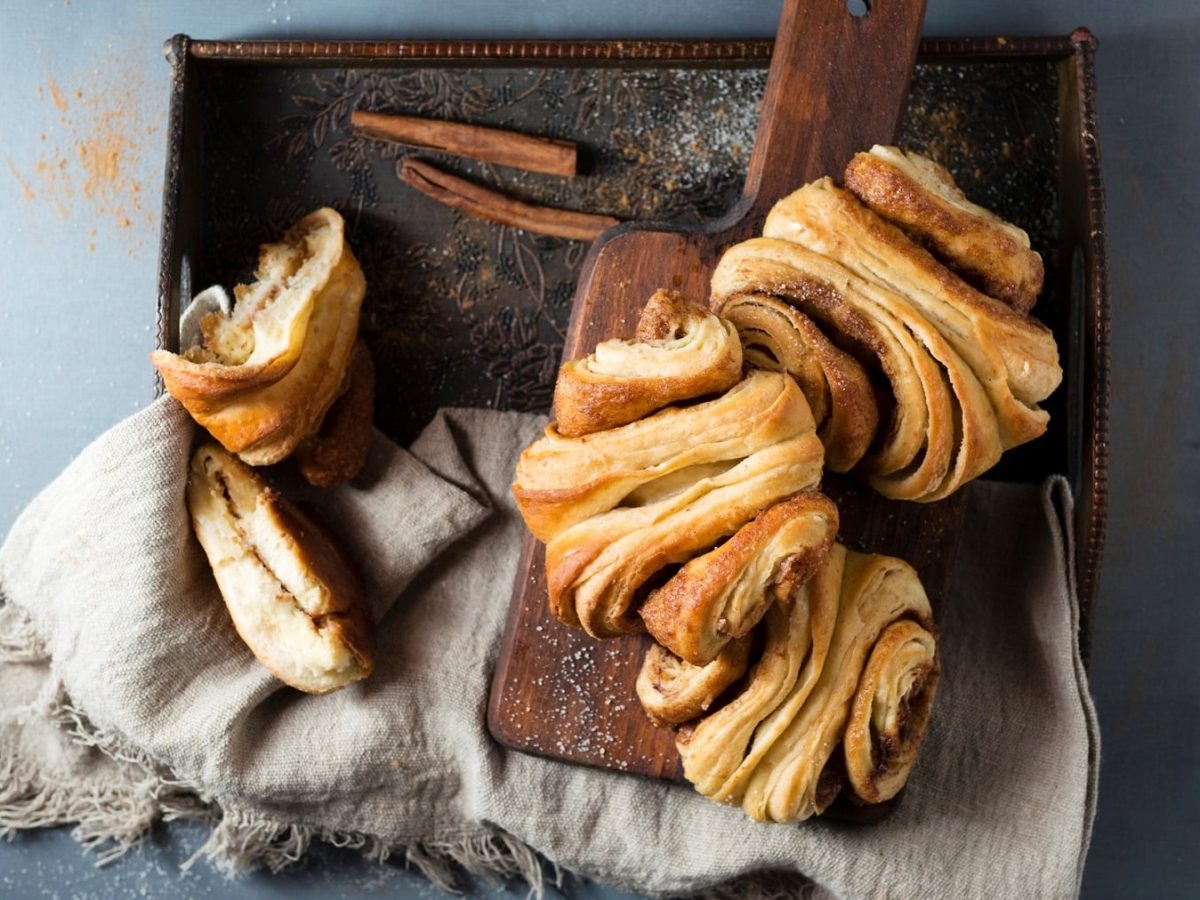 Ein paar vegane Franzbrötchen auf einem Tablett mit einer Stoffserviette in der Draufsicht.