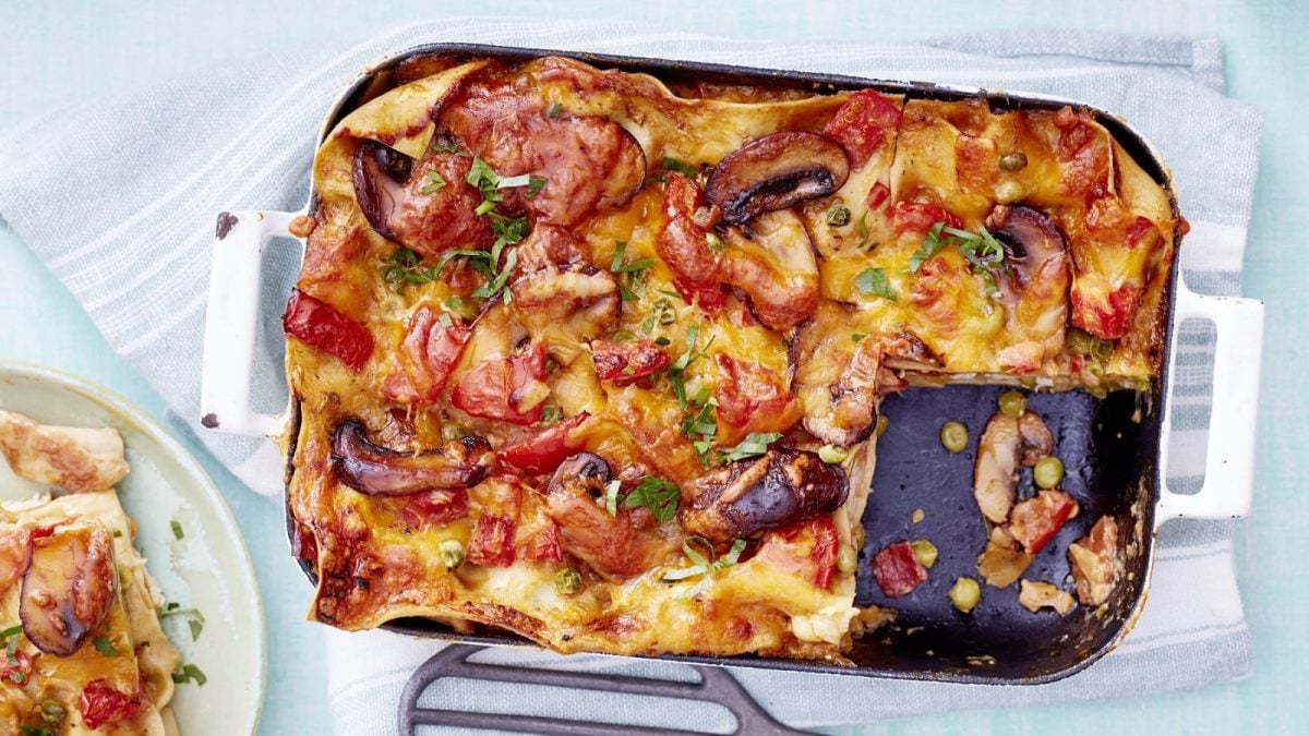 In einer Auflauf-Form ist eine Hähnchen-Lasagne angerichtet. Sie ist mit Pertersilie bestreut und mit Käse überbacken.