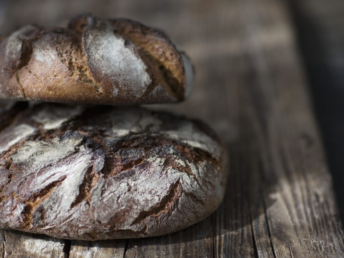 Ein Holzbrett mit Kohl-Speck-Brot darauf.