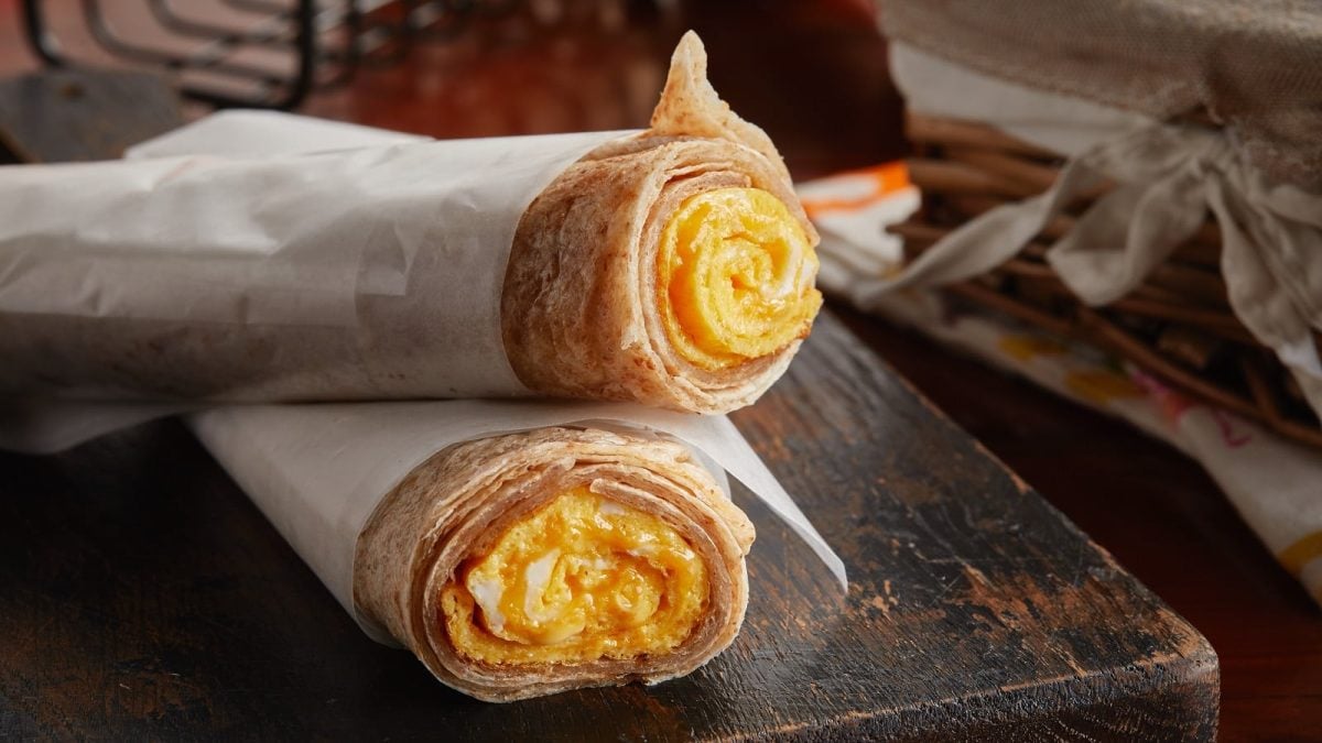 Zwei Chapati Egg Rolls auf einem Holzbrett.