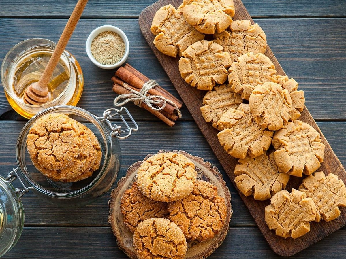 Erdnussbutterkekse in in einem Glas, Schüssel und auf einem Tablett.