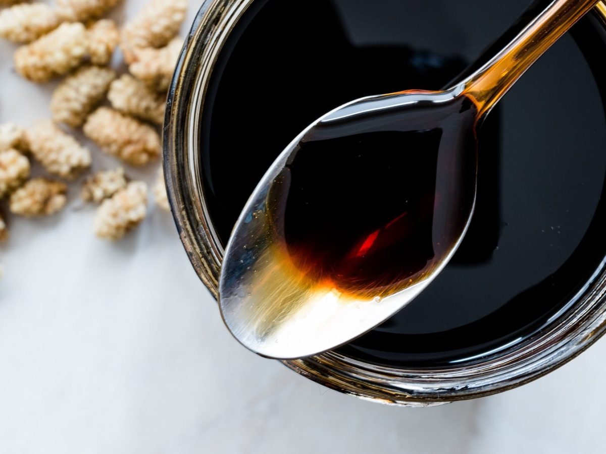 Ein Glas Kaffeesirup mit einem Löffel in der Draufsicht.