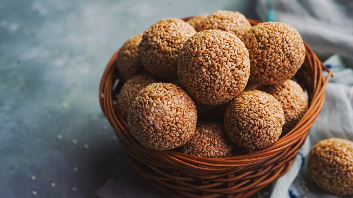 Eine braune Schale mit den Laddu-Kugeln auf grauem Untergrund.